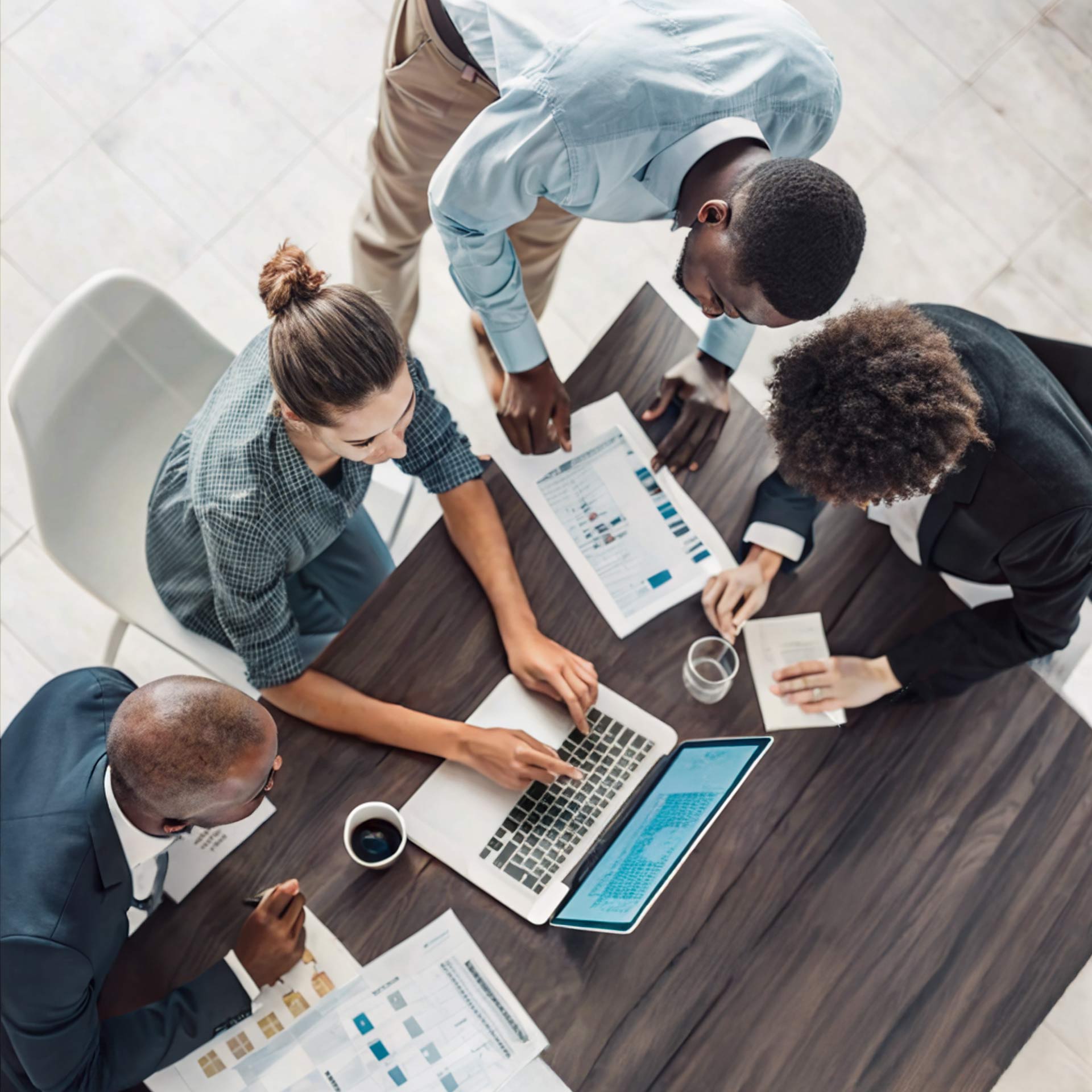 A birds-eye view of four people around a desk collaborating.